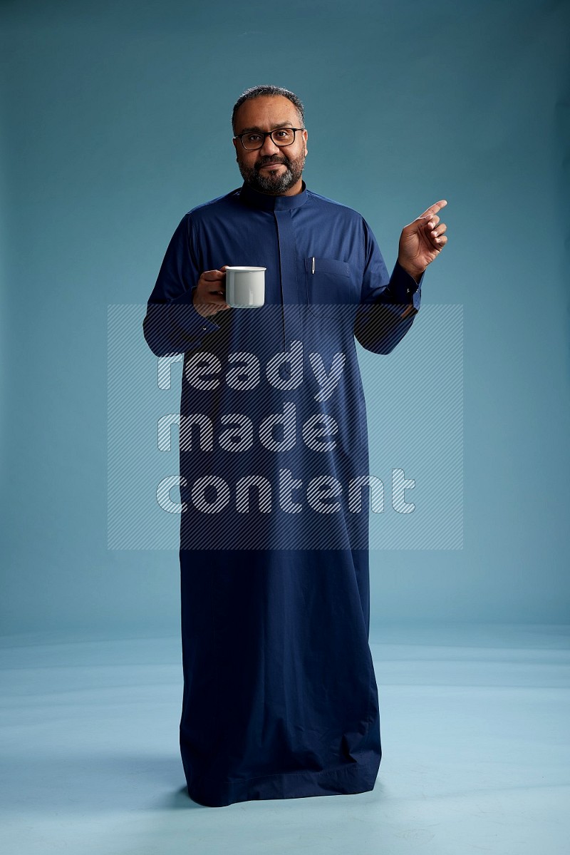 Saudi Man without shimag Standing drinking coffee on blue background