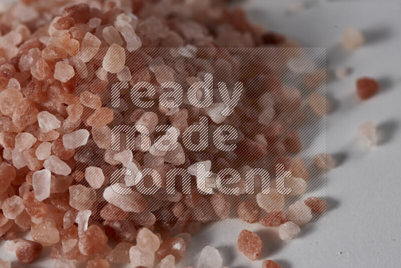 A bunch of coarse himalayan salt crystals on white background