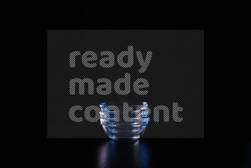 Glassware with rim light in blue and white against black background