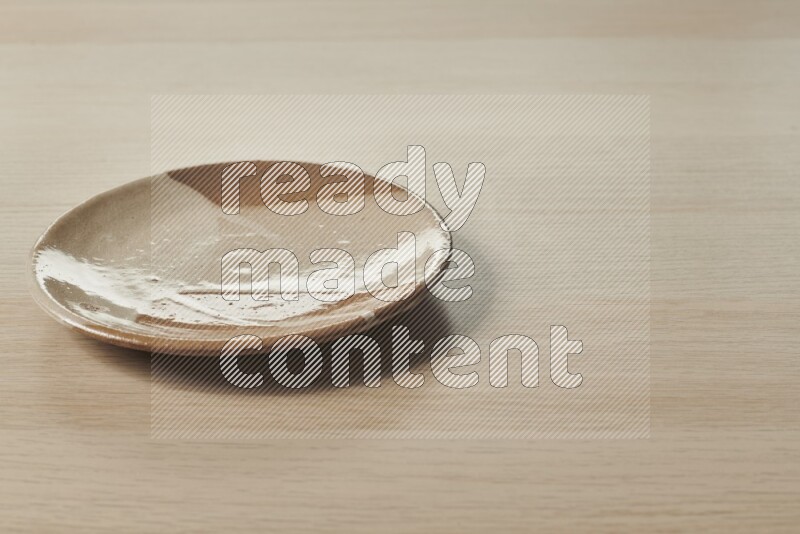 A multicolored pottery plate on light wooden background