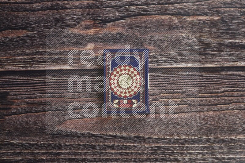 Quran with a prayer beads on wooden background