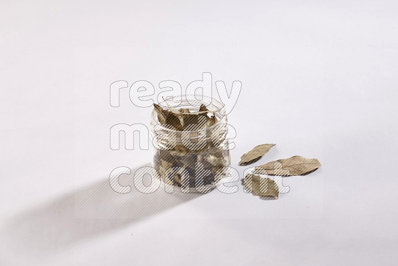 A glass jar filled with laurel bay on white flooring in different angles
