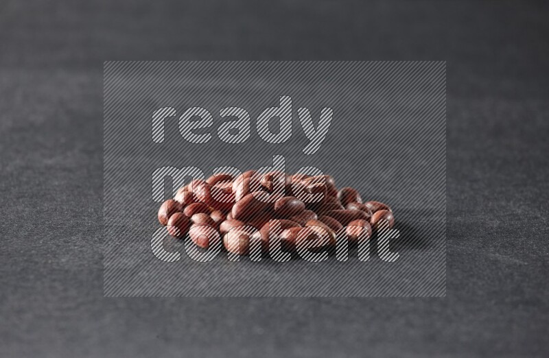 A bunch of red skin peanuts on a black background in different angles