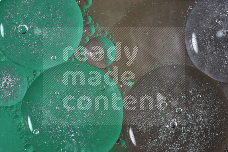 لقطات مقربة لفقاعات من الزيت على سطح الماء باللون الأخضر والبني