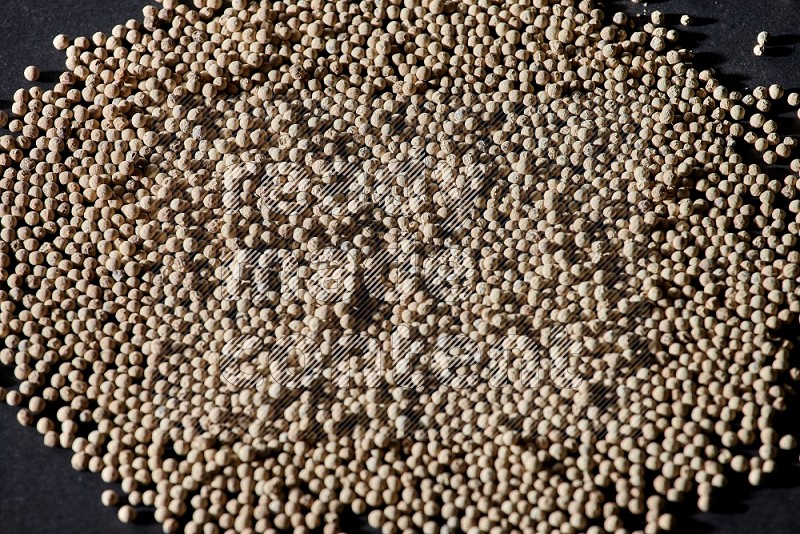 White pepper beads on black flooring