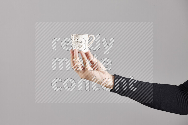 A woman in black abaya holding different pottery essentials in different positions