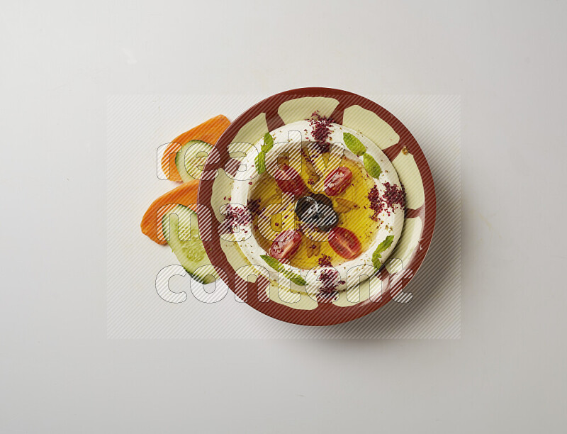 Lebnah garnished with Cherry tomato, mint & sumak  in a traditional plate on a white background