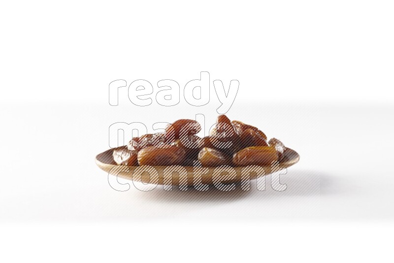 Dates in a wooden plate on white background