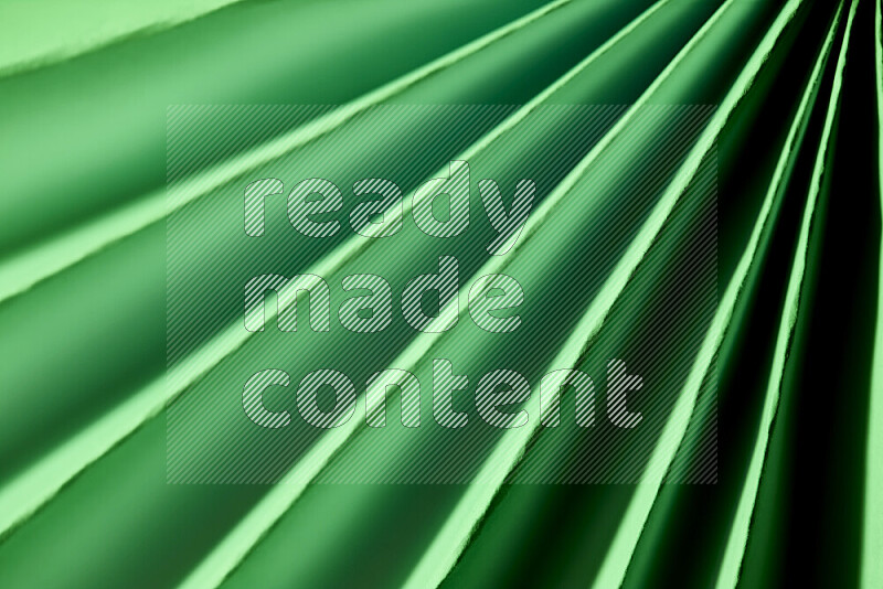 An image presenting an abstract paper pattern of lines in green tones
