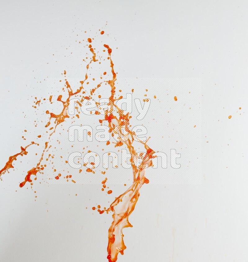 Orange liquid splash and drops on white background