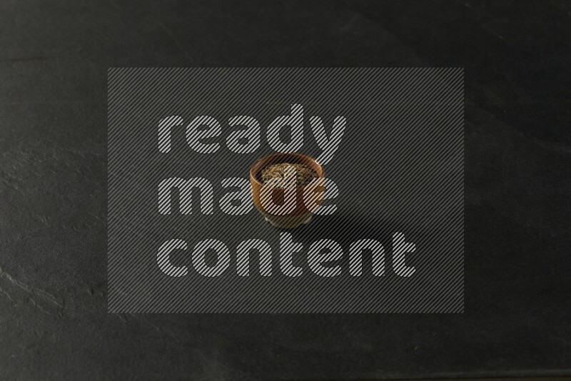 multi color round sauce bowl filled with herbs on grey textured countertop