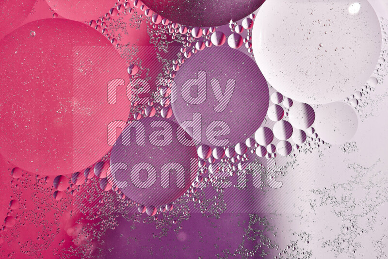 Close-ups of abstract oil bubbles on water surface in shades of white, purple and pink