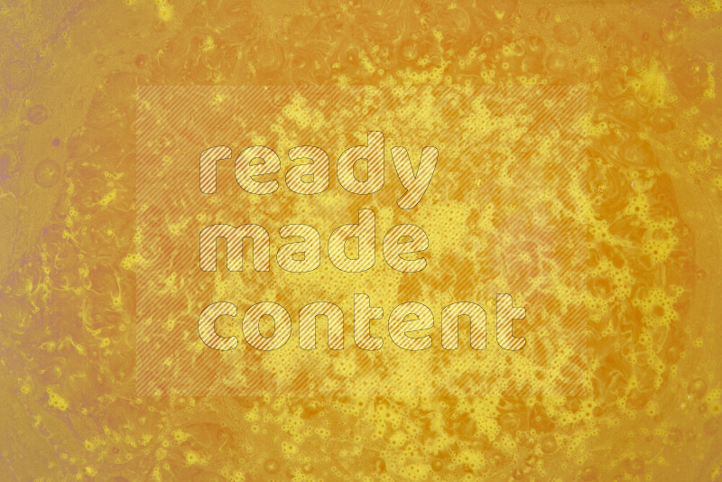 The image captures a dramatic splatter of yellow paint over a white backdrop