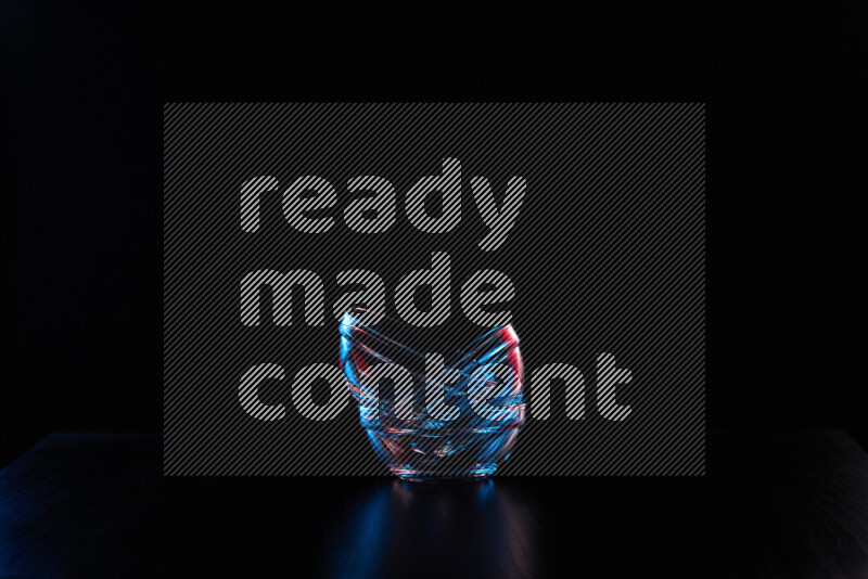 Glassware with rim light in red and blue against black background