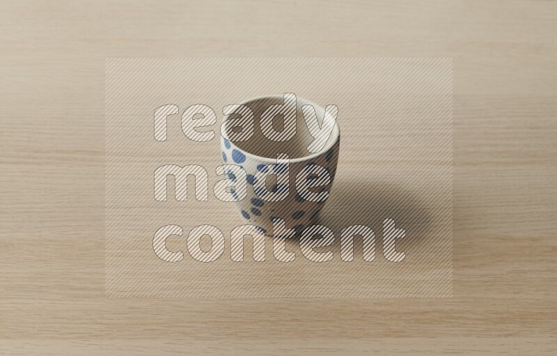 A pottery cup on light wooden background