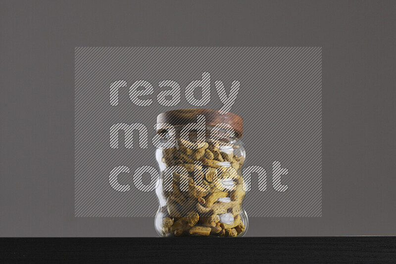 Turmeric in a glass jar on black background