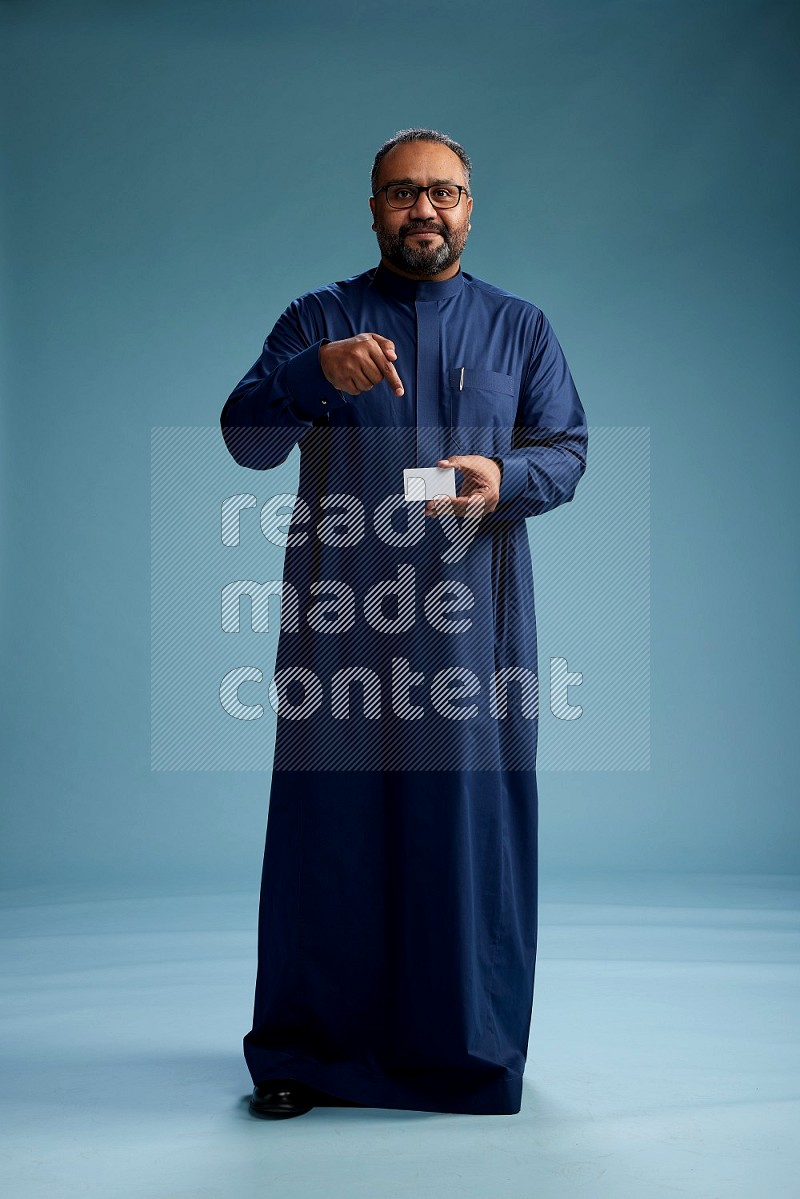 Saudi Man without shimag Standing holding ATM on blue background