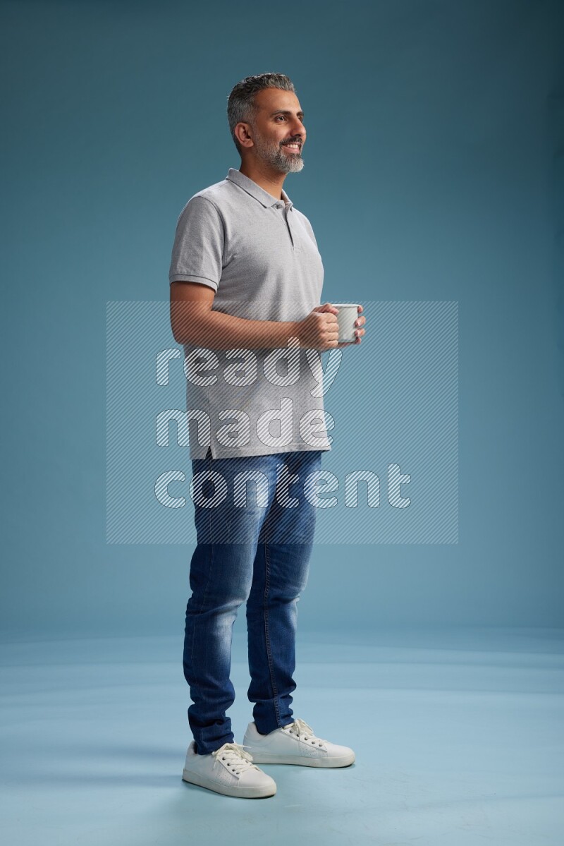 Man Standing drinking coffee on blue background