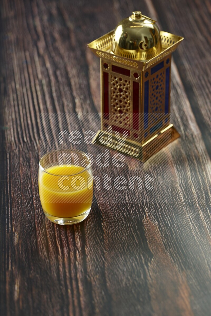 A golden lantern with different drinks, dates, nuts, prayer beads and quran on brown wooden background