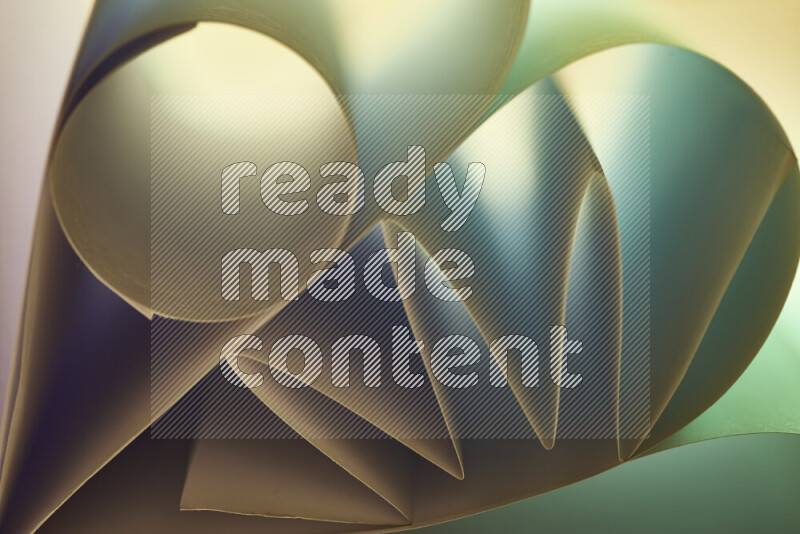An artistic display of paper folds creating a harmonious blend of geometric shapes, highlighted by soft lighting in green and warm tones