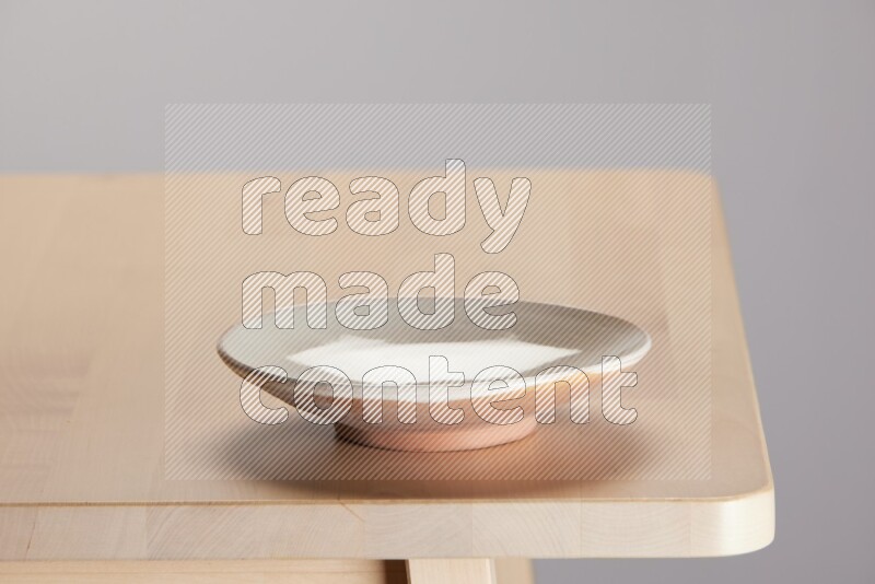 multi-colored pottery Plate on a wooden table edge