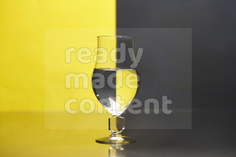 تظهر الصورة أواني زجاجية ممتلئة بالماء موضوعة على خلفية من اللونين الأصفر والأسود