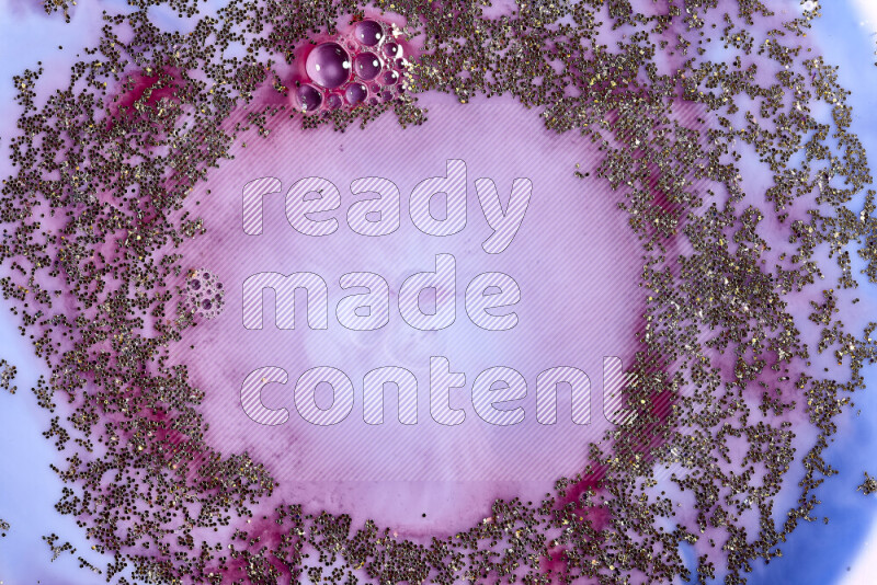 لقطة مقربة لبريق ذهبي متلألئ منتشر على خلفية من اللون الأزرق والأحمر في حركات دائرية