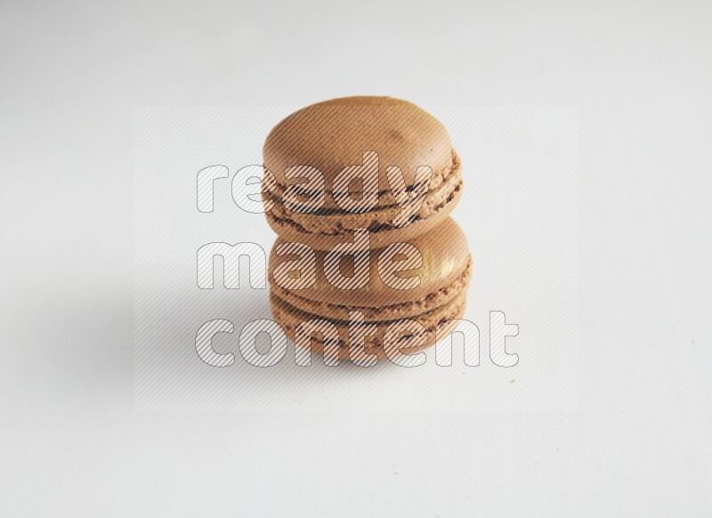 45º Shot of two Brown Coffee macarons on white background