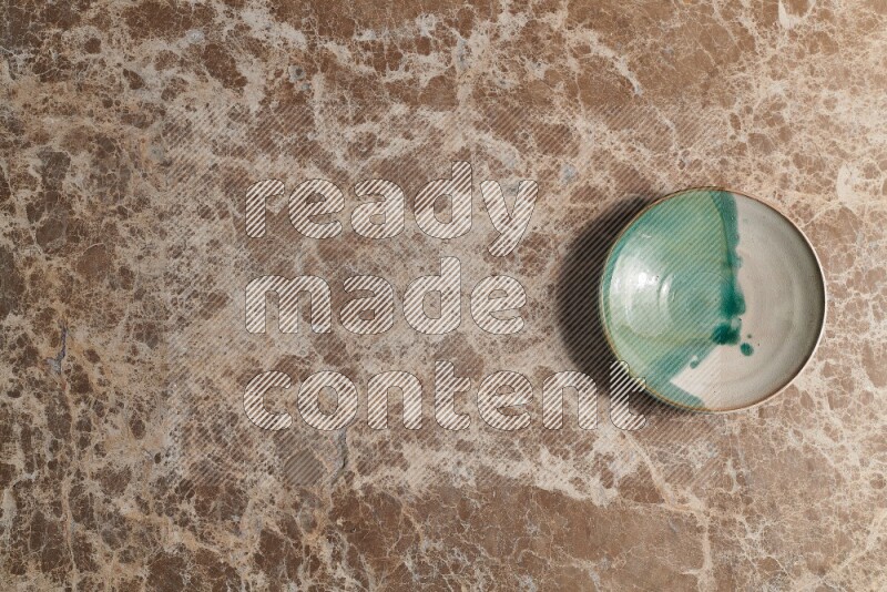 A decorative pottery plate on beige marble background