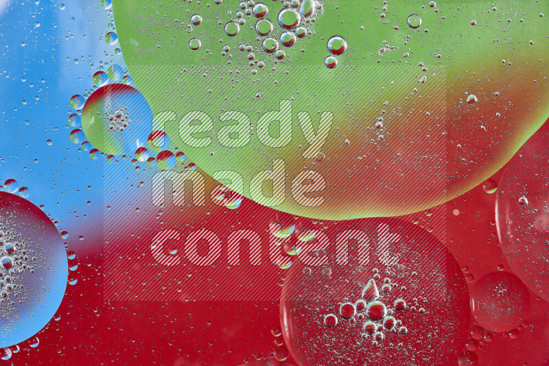 Close-ups of abstract oil bubbles on water surface in shades of red, green and blue
