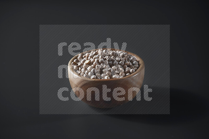 Chickpeas in a wooden bowl on grey background