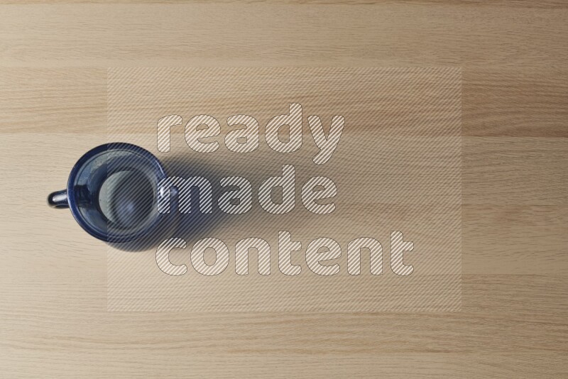 A colored glass jug on light wooden background