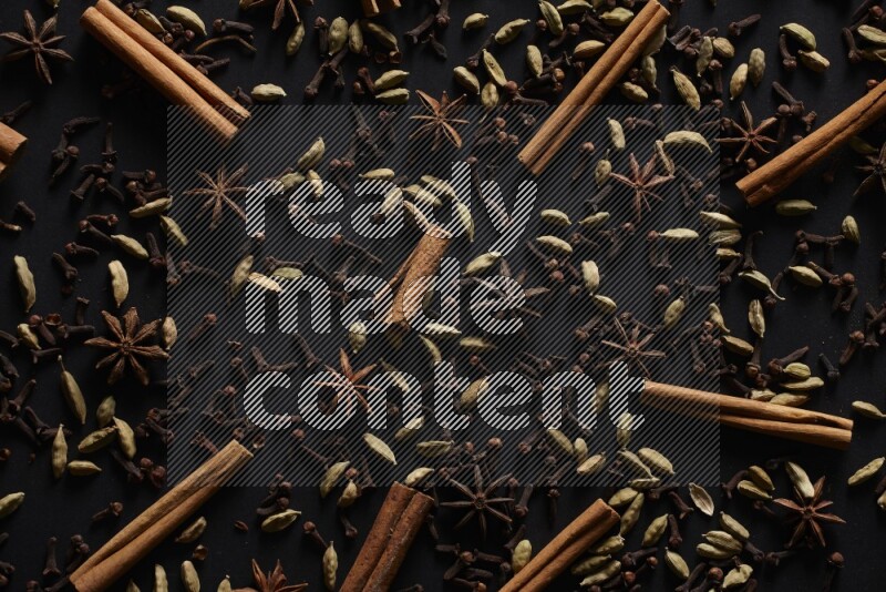 Cinnamon Sticks, Star anise, Cardamom and cloves on a black background