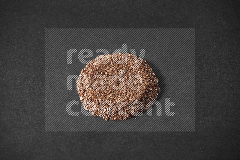 Flax Seeds in a circle shape on a black Flooring