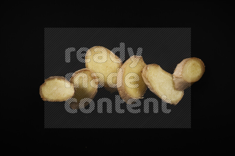 Fresh ginger slices on black background