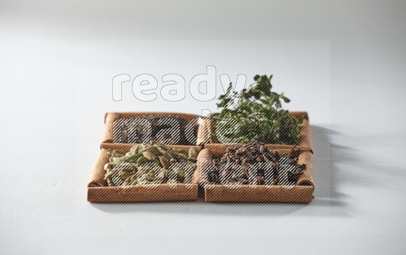 4 squares of cinnamon sticks full of tea, cardamom, mint and cloves on white flooring