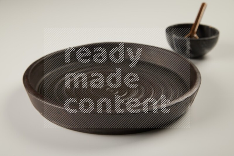 black pottery plate and black bowls on white background