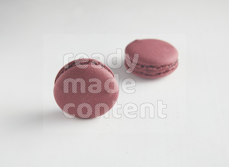 45º Shot of two Red Cherry macarons on white background