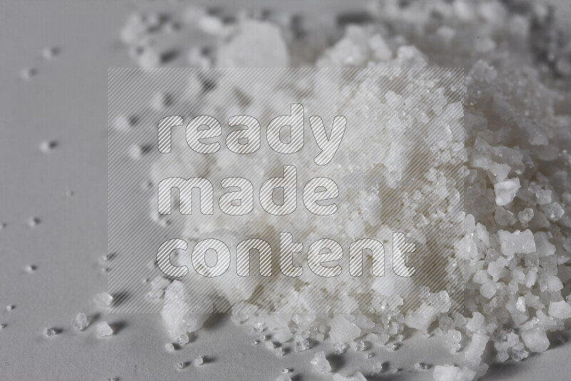 A bunch of coarse sea salt crystals on white background