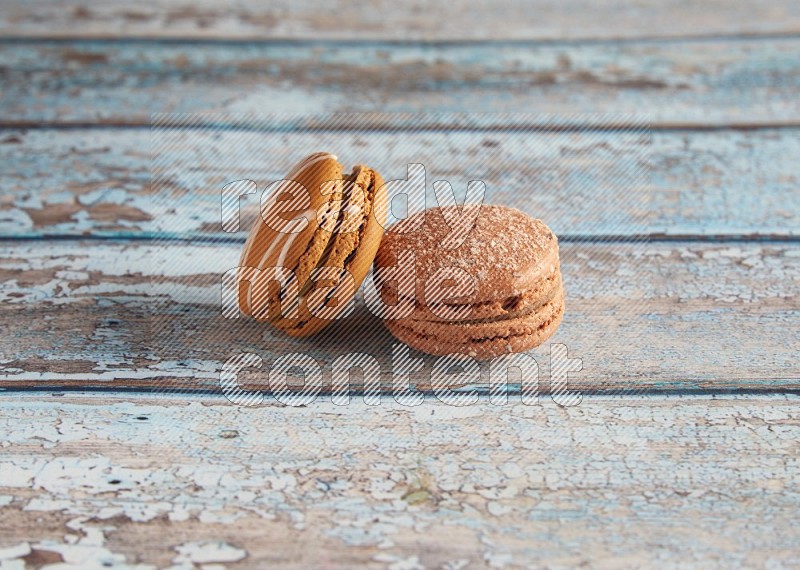 45º Shot of of two assorted Brown Irish Cream, and Brown Hazelnuts macarons  on light blue background