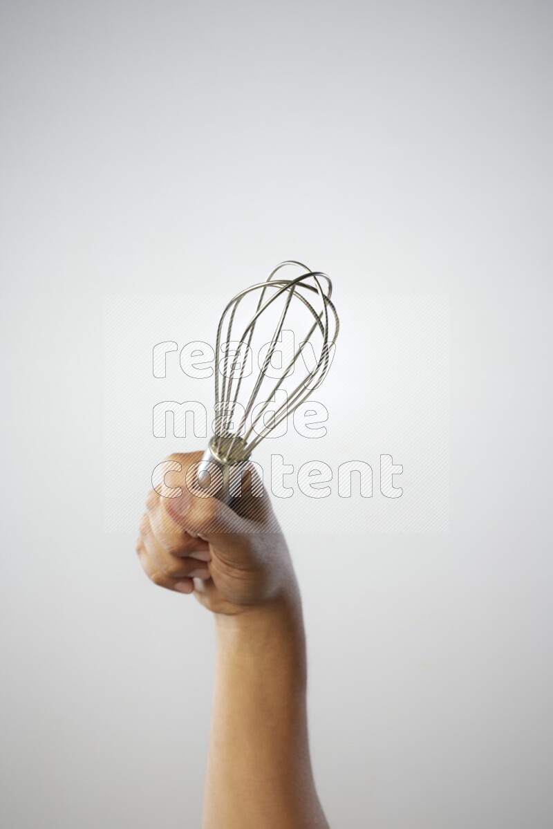 Male Hand Holding Whisk on white background