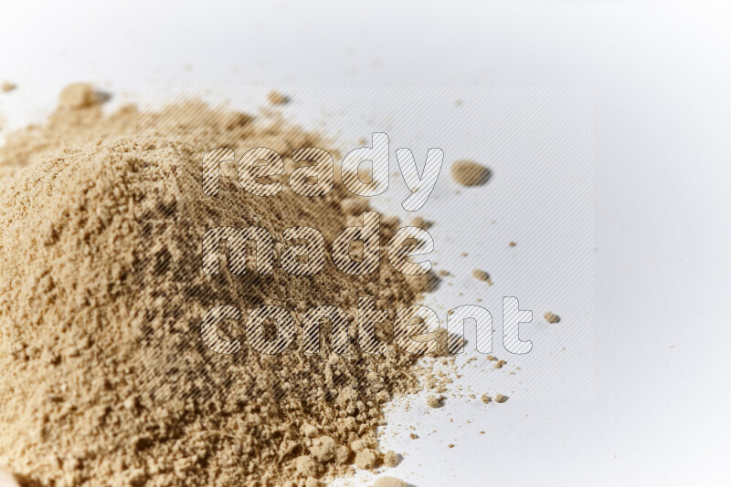 A bunch of ground ginger powder on white background