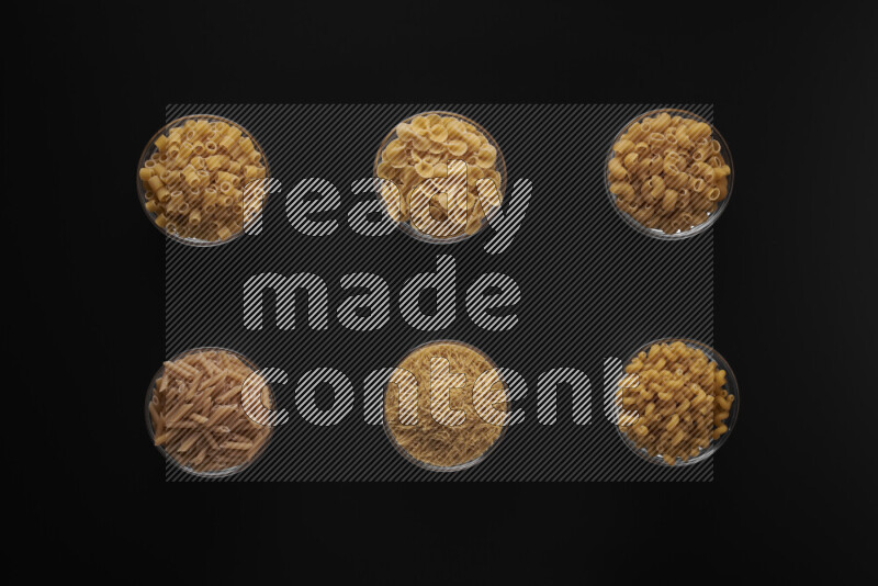 أنواع مختلفة من المعكرونة في أوعية زجاجية علي خلفية سوداء