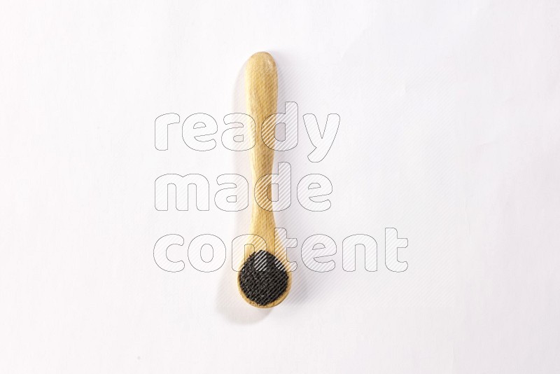A wooden spoon full of black seeds on a white flooring in different angles