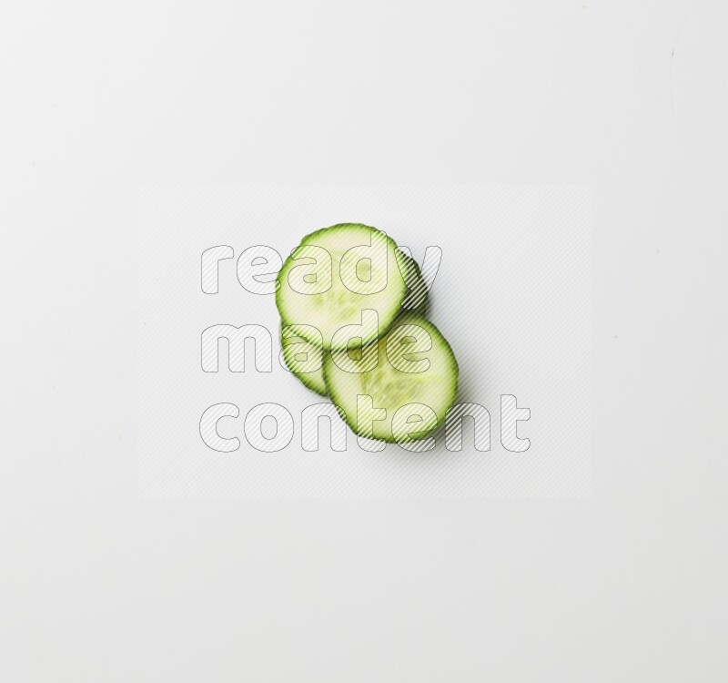 three cucumber slices on white background