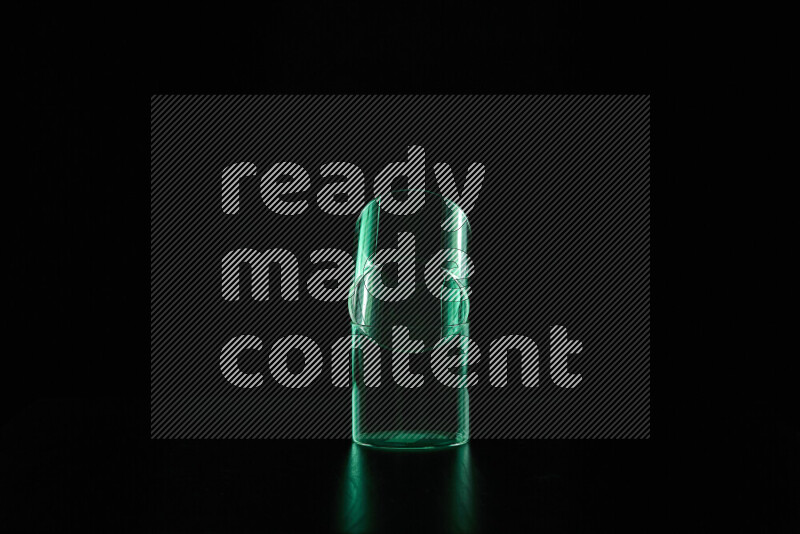 Glassware with rim light in green against black background