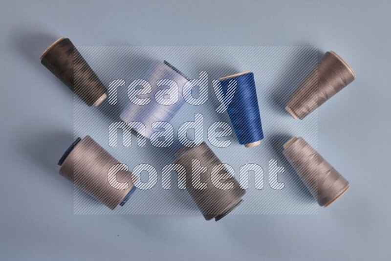 مجموعة من أدوات الخياطة والتفصيل رمادية اللون على خلفية زرقاء