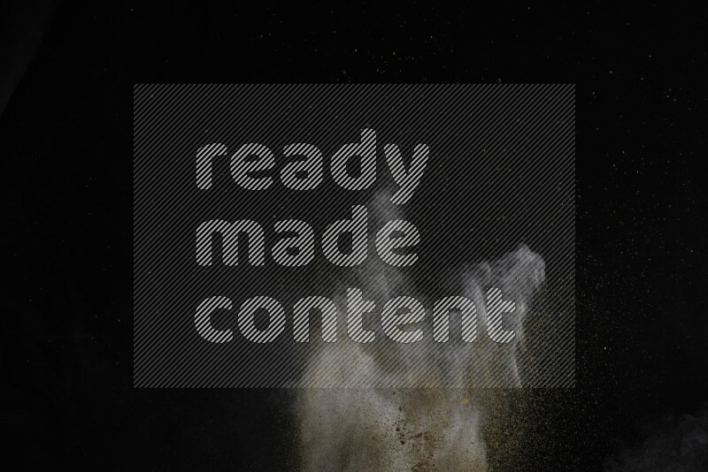 A side view of brown powder explosion on black background