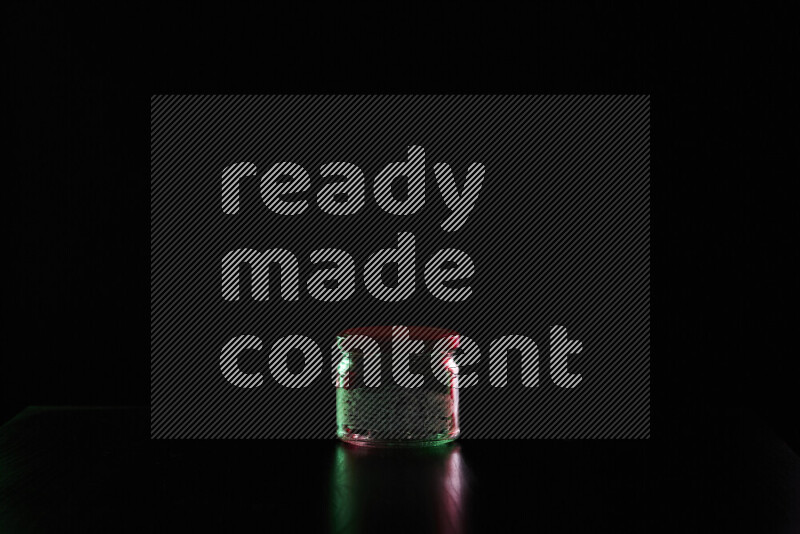 Glassware with rim light in red and green against black background