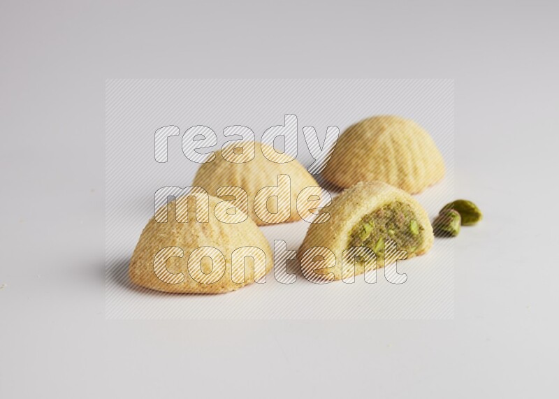 Four Pieces of Maamoul filled with pistachio  paste one of them is cut direct on white background